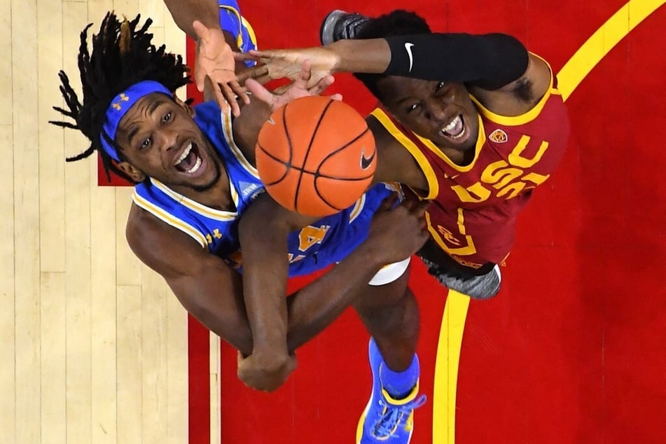 Jalen Hill of the UCLA Bruins (l) and Onyeka Okongwu of the USC Trojans fight for a rebound in the first half of the UCLA vs. USC game at Galen Center.