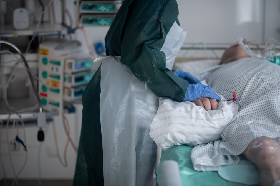Eine Mitarbeiterin der Pflege betreut einen Covid-Patienten auf der Intensivstation einer Uniklinik.