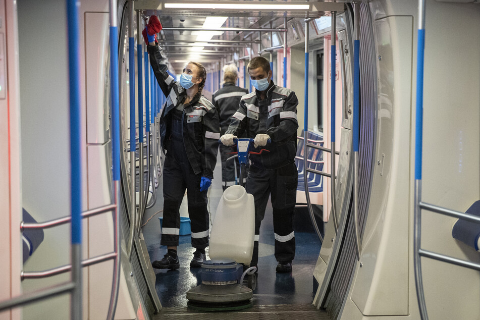 Mitarbeiter des Moskauer U-Bahn-Depots desinfizieren den Innenraum eines Zugabteils.