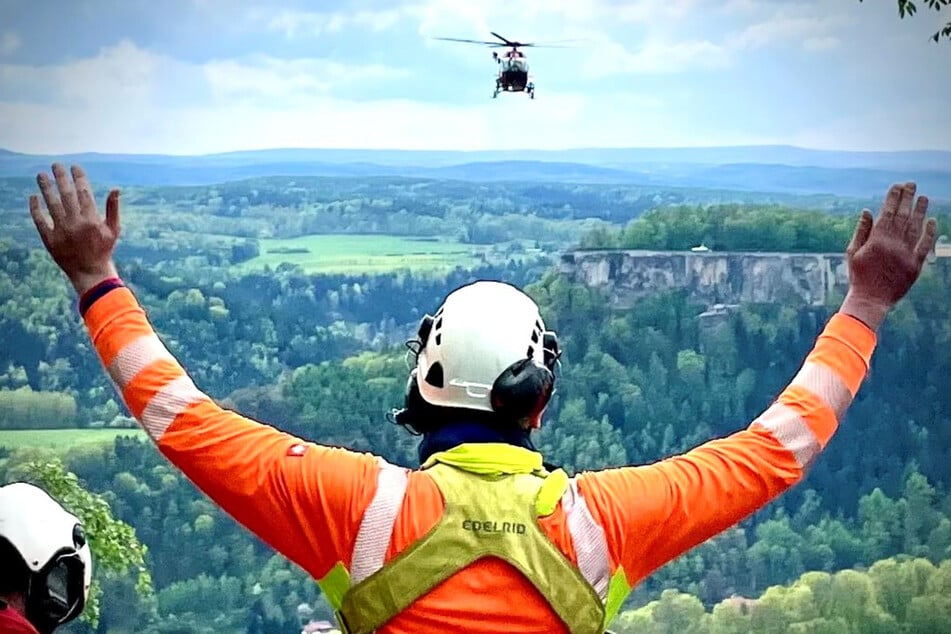 Ein Bergretter leitet einen Rettungshubschrauber heran, nachdem am Lilienstein ein 73-jähriger Wanderer zusammengebrochen war.