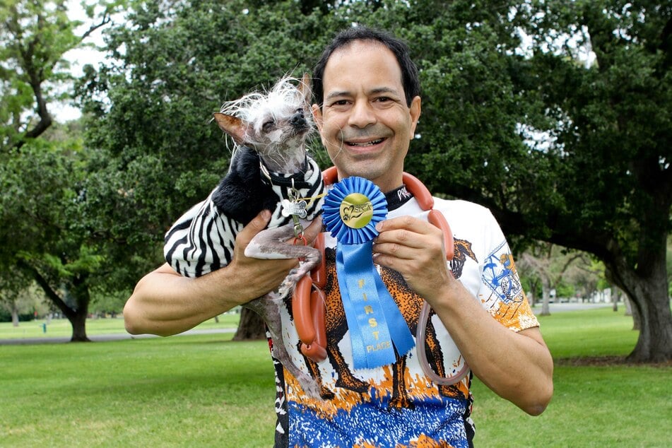 Rascal poses with his owner Dane Andrew after once again winning the title of ugliest dog in the world.