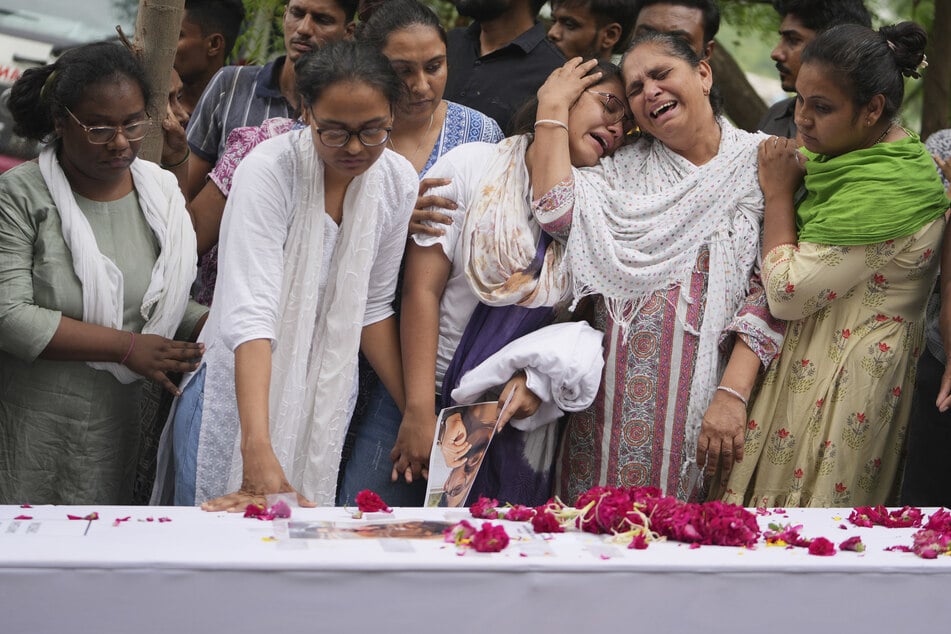 Familienmitglieder eines Opfers des Air-India-Flugzeugabsturzes trauern während seiner Beisetzung.