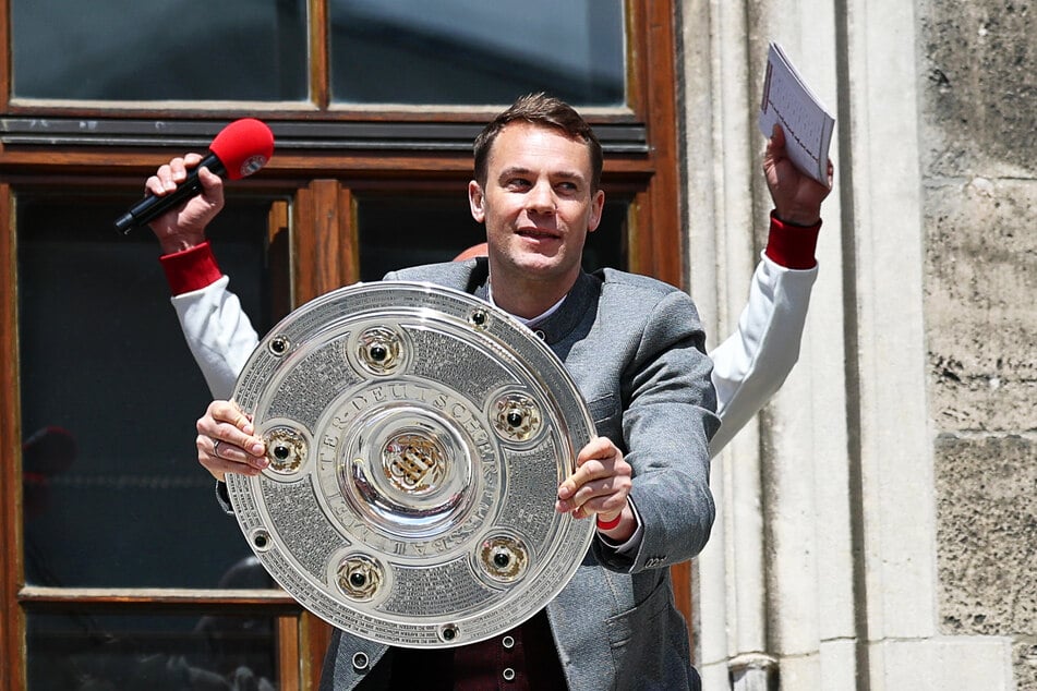 Torhüter Manuel Neuer jubelt mit der Meisterschale auf dem Rathaus-Balkon.