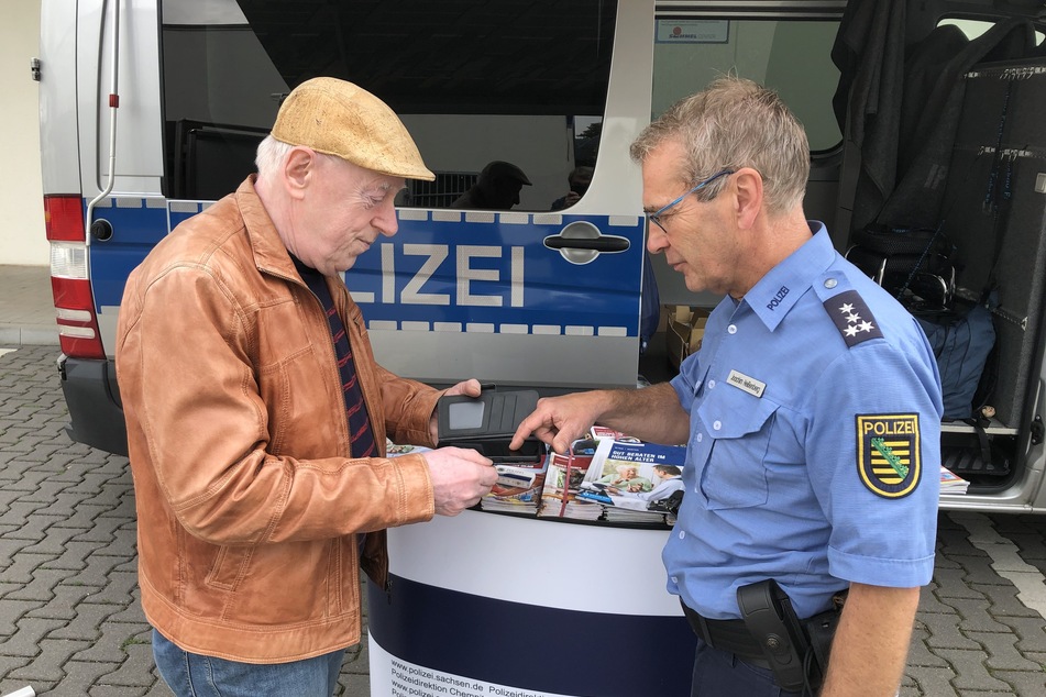 Polizeihauptkommissar Joachim Heißenberg (59) erklärt dem Rentner Uwe Krieg (73), wie er sein Android-Telefon schützen kann.