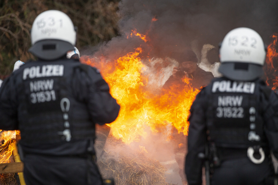 Während die Polizei die Ortslage Lützerath räumt, brennen Strohballen, die von Aktivisten angezündet wurden.