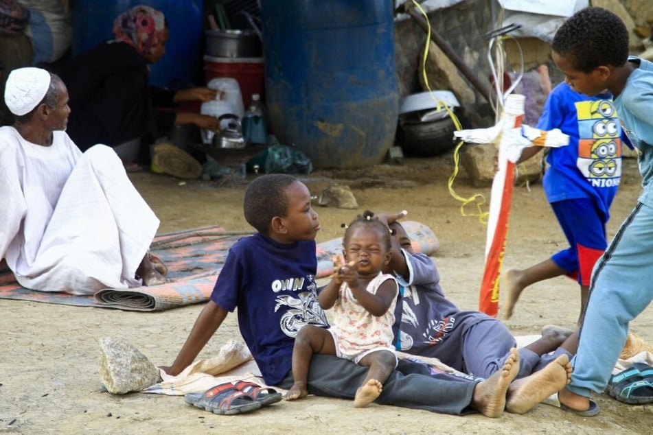 People already displaced by conflict rest by tents at a makeshift campsite they were evacuated following deadly floods in the eastern city of Kassala, Sudan, on August 11, 2024.