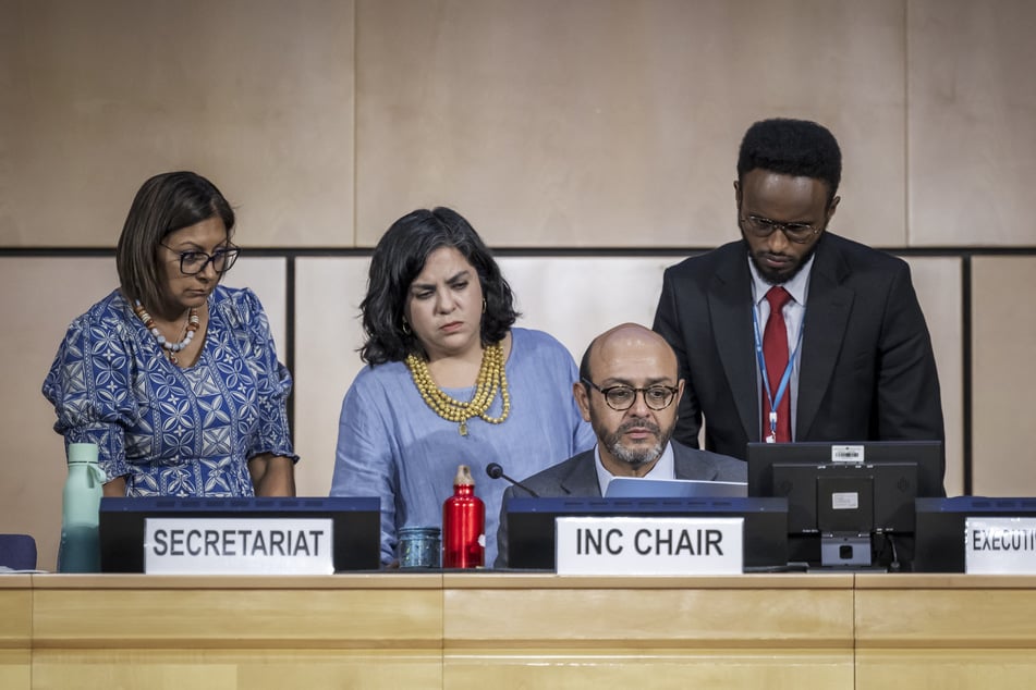 Chairman of the negotiations on global treaty on plastic pollution Ecuadorian Ambassador Luis Vayas Valdivieso (second from r.) looks on with members of his office prior to the opening of a plenary assembly in Geneva on August 15, 2025.