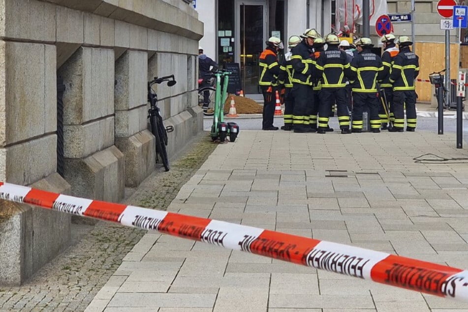 Einsatzkräfte der Feuerwehr stehen am Alten Wall in Hamburg.