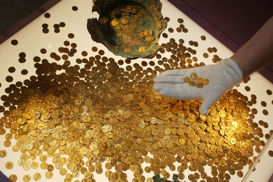 Römische Goldmünzen des Trierer Goldschatzes werden im Rheinischen Landesmuseum Trier in einer Vitrine platziert.