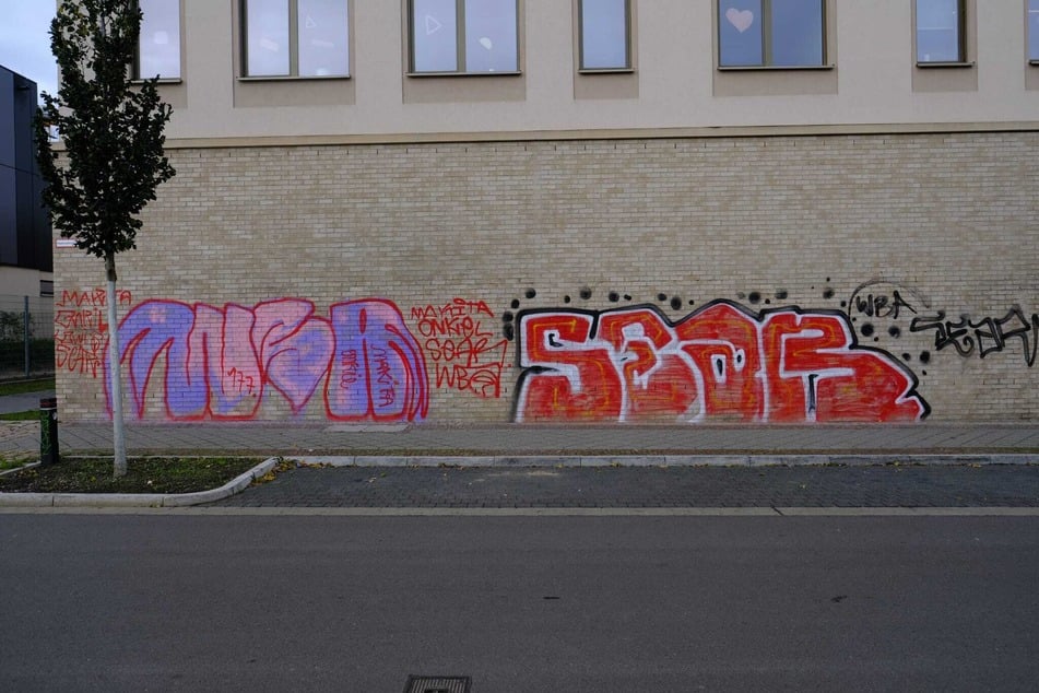 Mit roter Farbe gesprayte Riesen-Graffiti prangen auf der Grundschul-Fassade in der Gießerstraße.