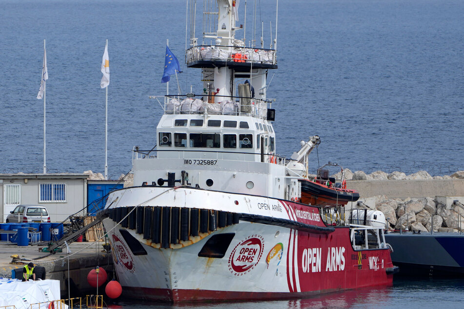 Hafenmitarbeiter bereiten die Hilfsgüter für den Gazastreifen auf einer Plattform neben dem angedockten Schiff der Hilfsorganisation Open Arms vor.