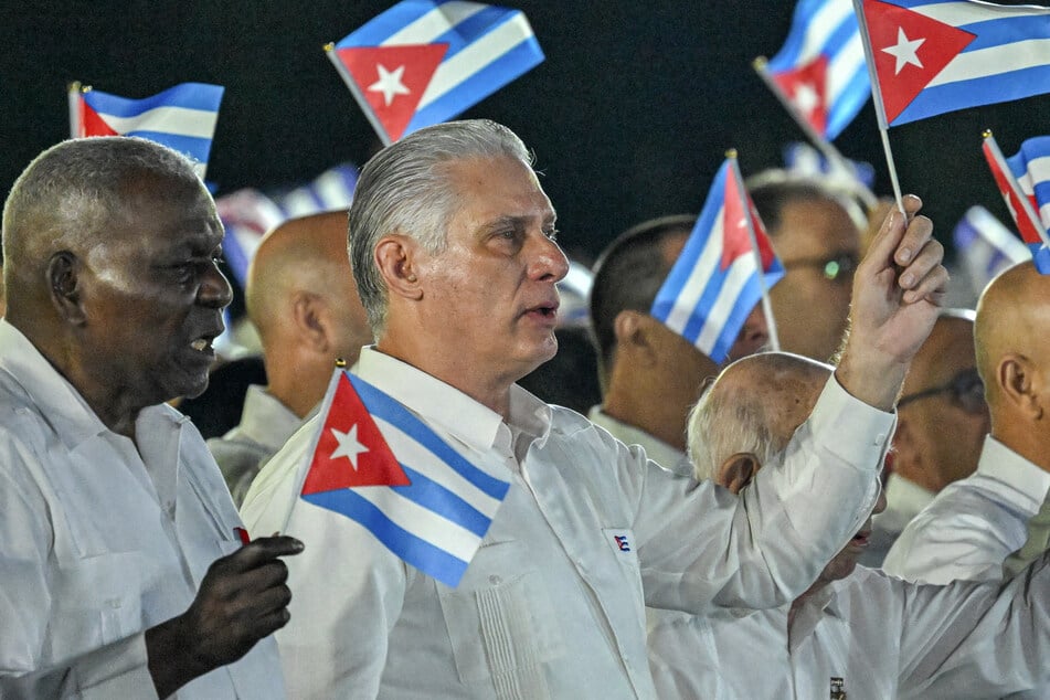 Cuba's President Miguel Díaz-Canel (r.) and head of Parliament Esteban Lazo (l.) wave paper flags during the 73rd anniversary celebration of the guerrilla assault on the Moncada Barracks, led by the late leader Fidel Castro and considered the start of the Cuban Revolution, in Pinar del Rio on July 26, 2026.