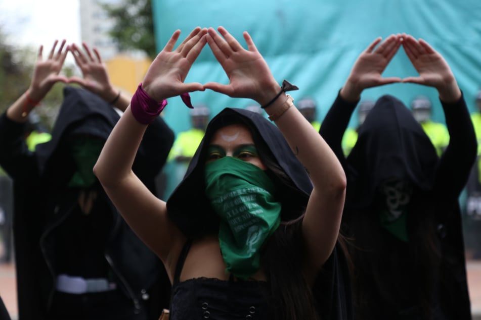 Kolumbien, Bogotá: Frauen bilden während einer Demonstration für ein Recht auf Abtreibung mit ihren Händen ein Dreieck.