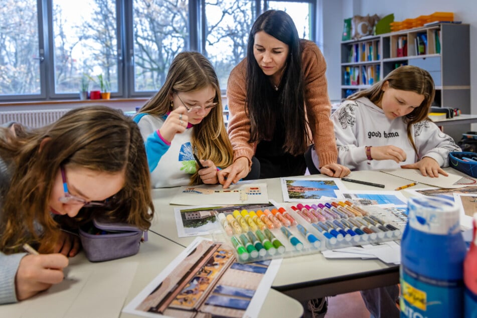 Lehrerin Tina Frauendorf (43) schaut sich an, welche Chemnitz-Motive Alexandra (13, v.l), Jasmina (12) und Anni (12) malen wollen.