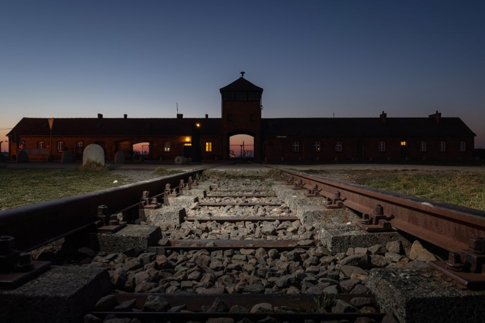 Der Blick von Eisenbahnschienen auf das Eingangsportal des ehemaligen Konzentrationslagers Auschwitz-Birkenau.
