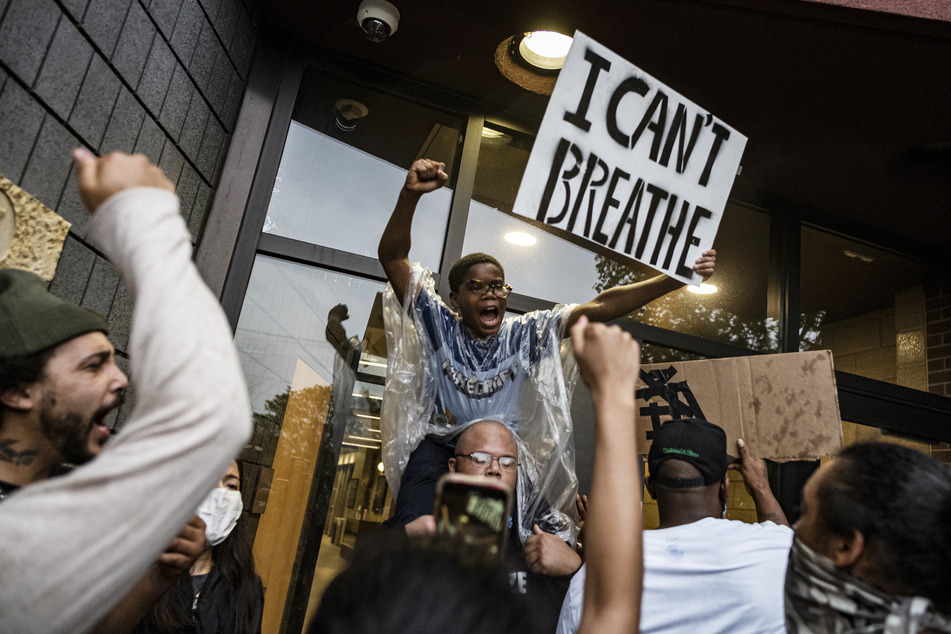 Demonstranten versammeln sich vor einem Polizeirevier und fordern mit einem Plakat mit der Aufschrift "I can't breathe" (dt. Ich kann nicht atmen) Gerechtigkeit.