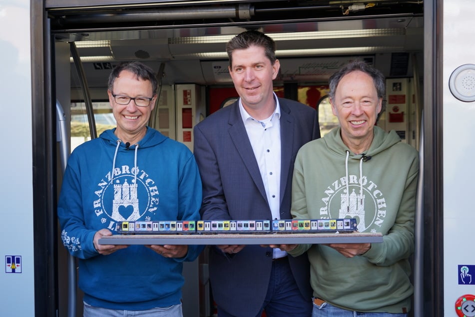 Gerrit und Frederik Braun zusammen mit S-Bahn-Chef Jan Schröder (50, M.) und der Modellversion der S-Bahn im Miniatur Wunderland-Design.