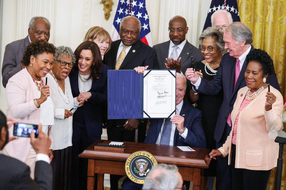 Vice President Kamala Harris (fourth From l.) posed with bill co-sponsors and President Joe Biden (c.) as he signed the Juneteenth National Independence Day Act into law in the East Room of the White House on Thursday.