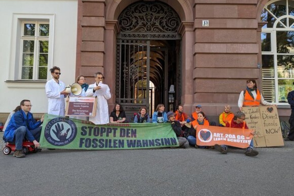 Die Klimaschutz-Gruppe "Eltern gegen die Fossilindustrie" kettete sich vor eine Bank-Filiale in der Berliner Friedrichstraße.