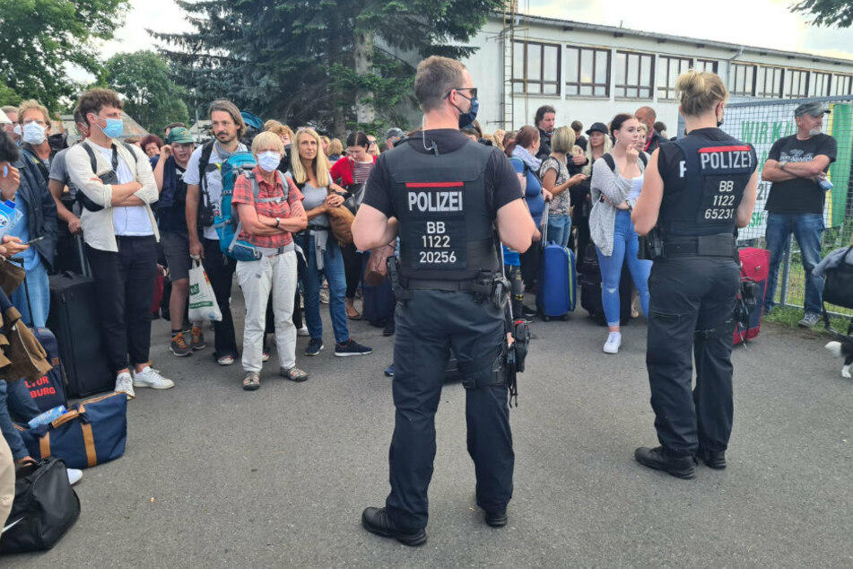 Polizisten der Bundespolizei stehen vor den Fahrgästen des ICE in Friesack.