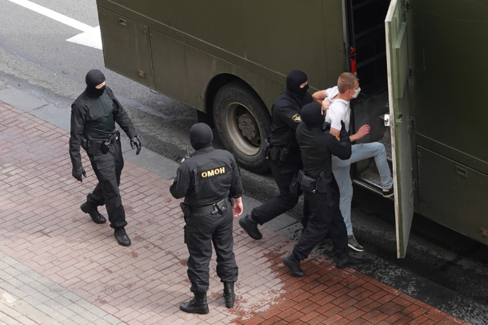 Ein Demonstrant wird von Bereitschaftspolizisten in einen Gefangenentransporter gebracht.