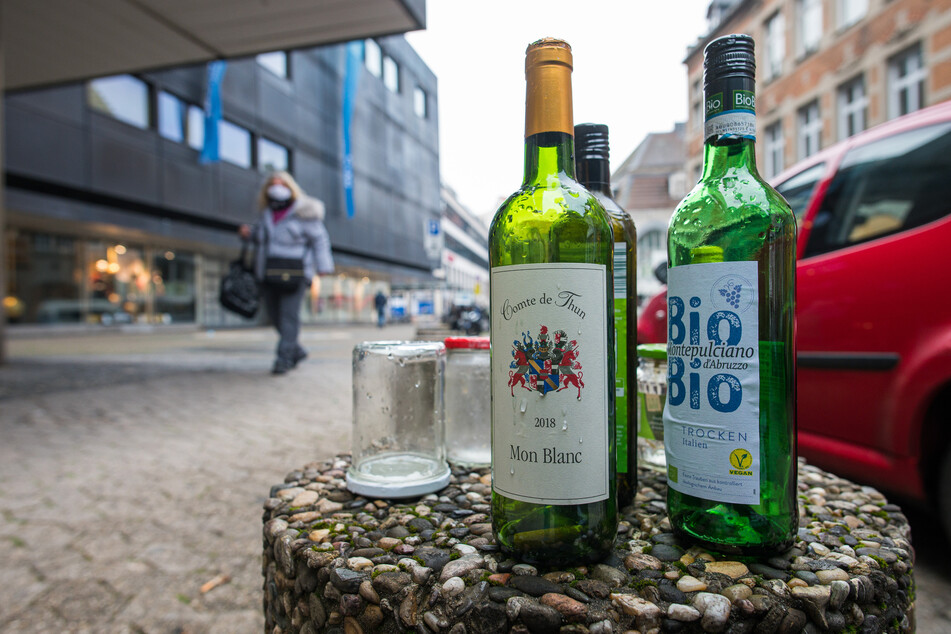 Leere Weinflaschen stehen auf einem Poller. (Symbolbild)