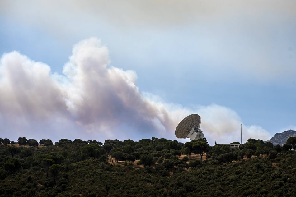 Smoke from a nearby fire drifts over a NASA antenna in Robledo de Chavela, Madrid, Spain, on July 24, 2026.