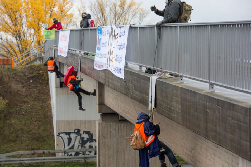 Mehrere Aktivisten seilen sich von einer Autobahnbrücke auf der A3 bei Wiesbaden-Breckenheim ab.