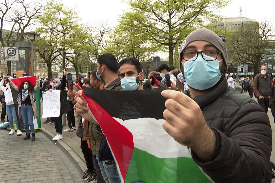 Teilnehmer der Demo halten Flaggen der Palästinensischen Autonomiegebiete.