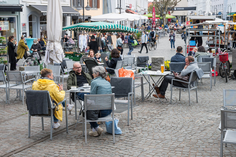 Saarland, Saarbrücken: Auf dem St. Johanner Markt in Saarbrücken sitzen Menschen im Außenbereich von Gastronomiebetrieben.