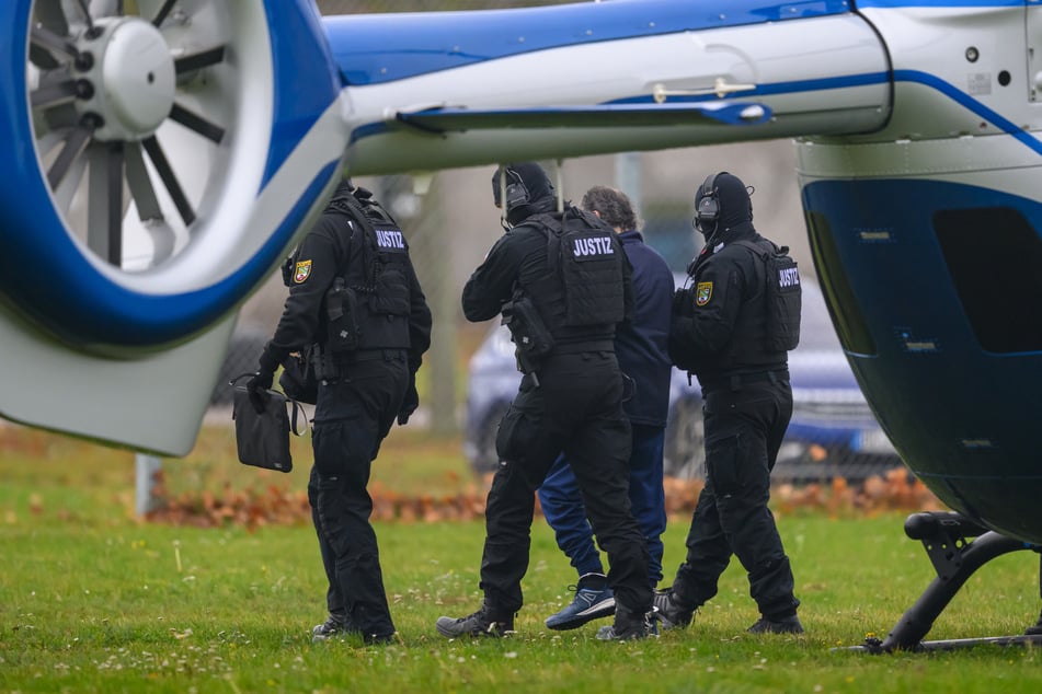 Taleb A. (51) wird von Justizpersonal nach der Landung im Hubschrauber in Magdeburg zur Fahrzeugkolonne geführt.