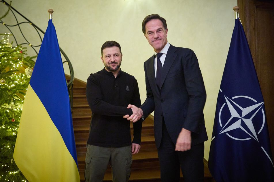 In this handout photograph taken and released by the Ukrainian Presidential Press Service on December 18, 2024, Ukraine's President Volodymyr Zelensky (l.) shakes hands with NATO Secretary General Mark Rutte (r.) prior to their talks on the sidelines of a EU-Western Balkans summit in Brussels.