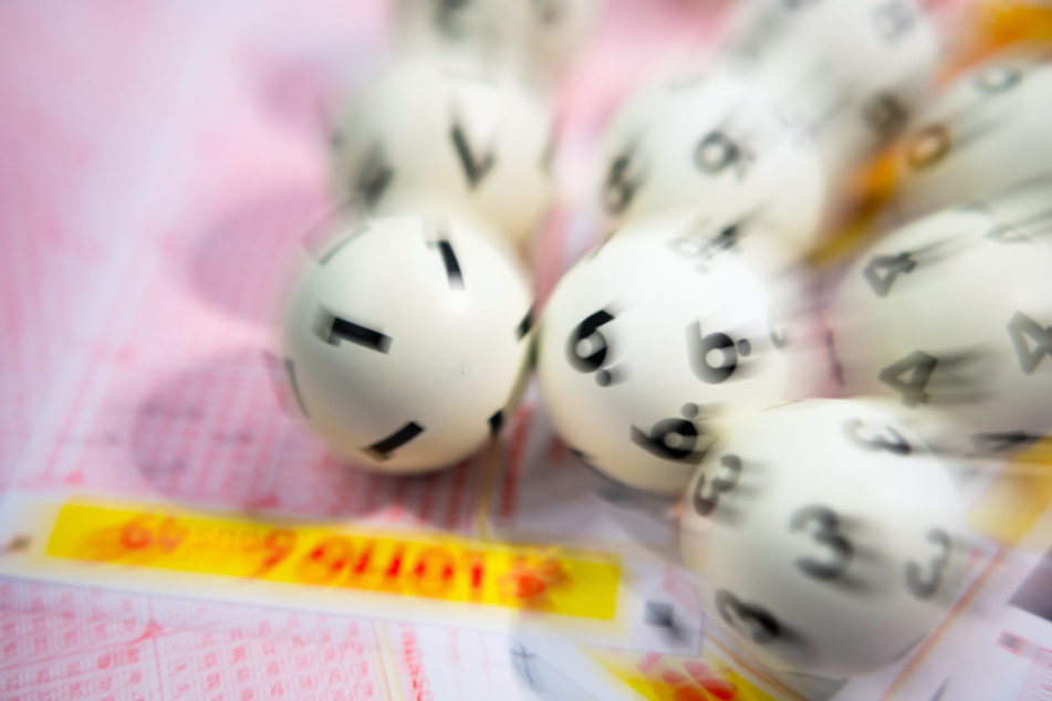 Lotto-Kugeln liegen auf einem Lottoschein. (Symbolbild)