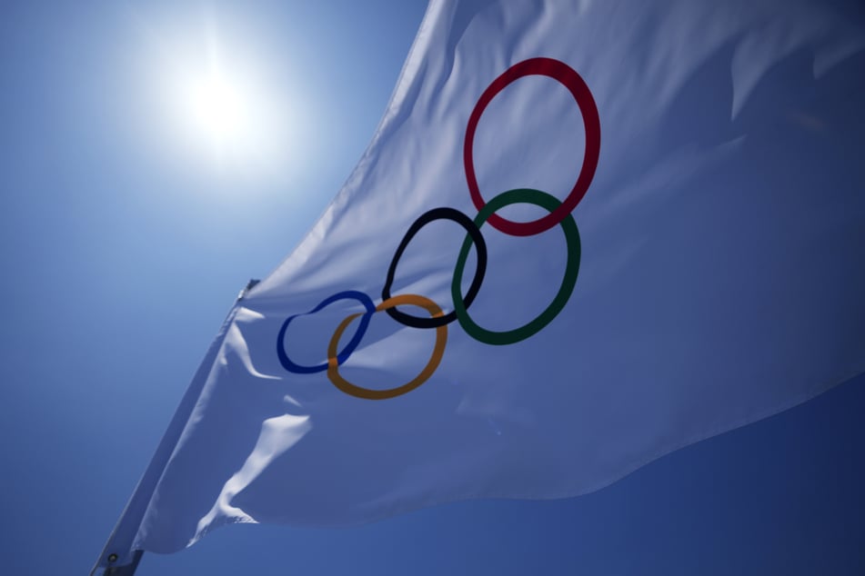 Die olympischen Ringe auf einer Flagge vor dem Stadion. Die Spiele beginnen am Freitag, dem 23. Juli.