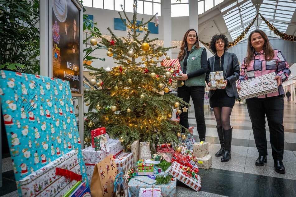 Am Wunschbaum im Neefepark übergaben Initiatorin Zaneta Wolff (41, r.) und Manja Böttcher (49, M.) vom Geschäft "JeansFritz", die Geschenke an Kristina Kisser (40) vom Kinderheim.