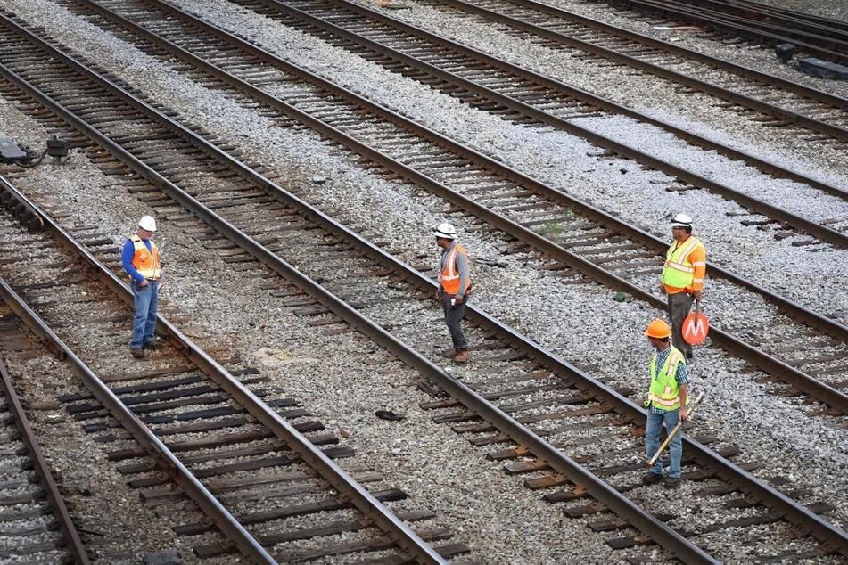 Workers service the tracks at the Metra/BNSF railroad yard outside of downtown Chicago, Illinois.