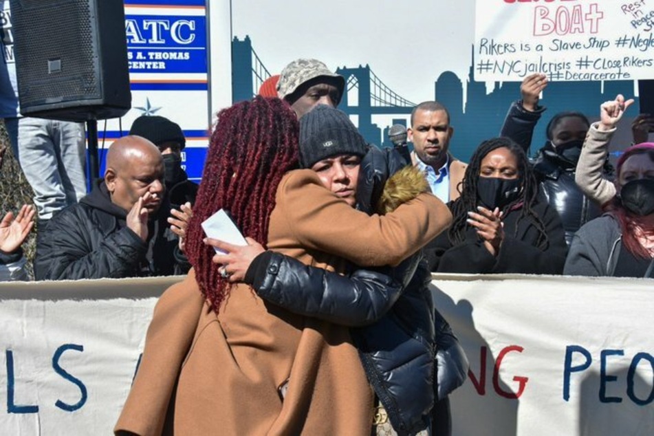 Olurin hugs the mother of Stephen Kadu, the 12th detainee to die at Rikers in 2021.