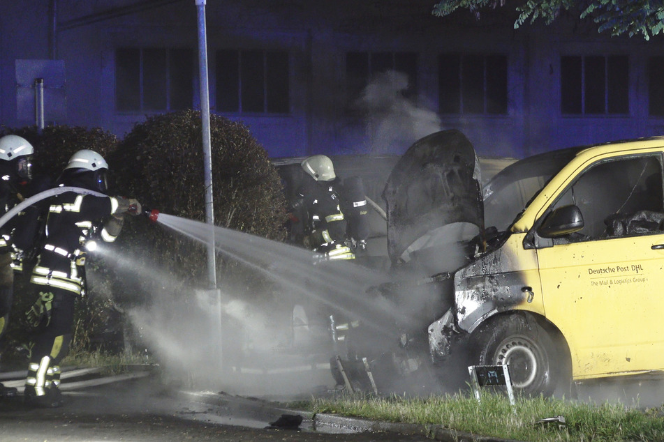 Die Kameraden der Feuerwehr löschen die Flammen an einem der Postfahrzeuge. Zwei Transportwagen brannten komplett aus, ein dritter wurde stark beschädigt.