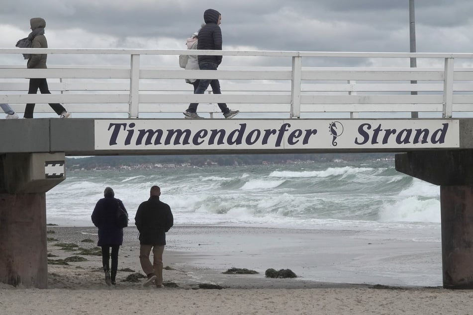Besucher gehen über eine Brücke am Timmendorfer Strand.