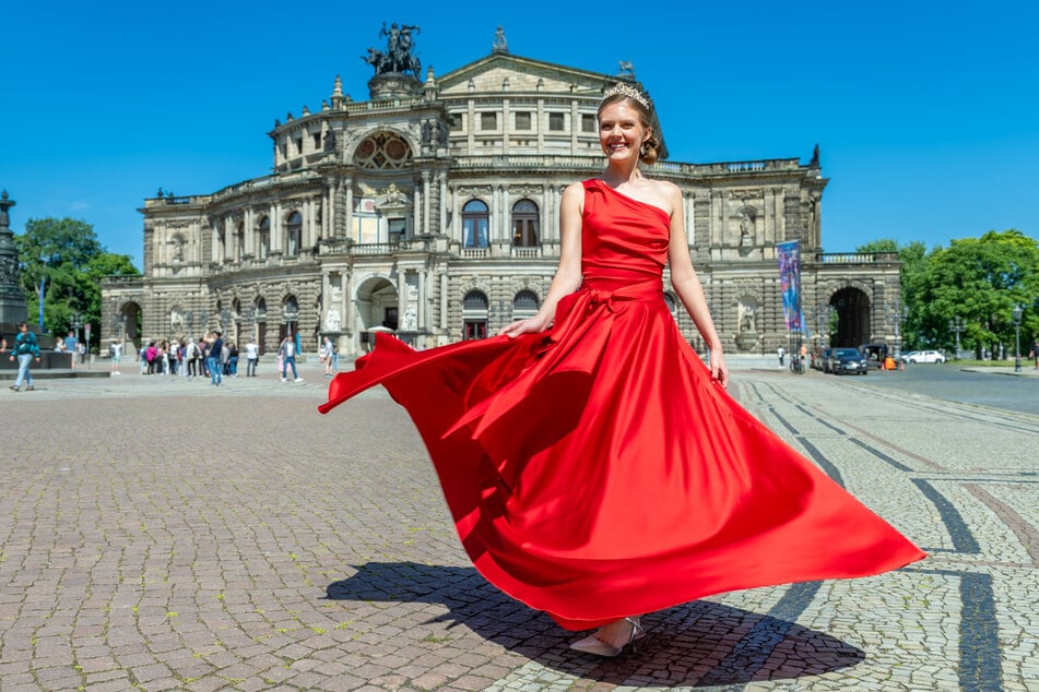 Josefine Maja Giebe lässt das rote Debütantenkleid vor der Semperoper fliegen.
