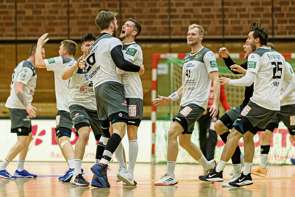 Die Spieler des HC Elbflorenz feiern ausgelassen ihren Helden Nils Kretschmer (4.v.l.). Der hatte in Bietigheim mit seinem dritten verwandelten Siebenmeter den Sieg in letzter Sekunde perfekt gemacht.