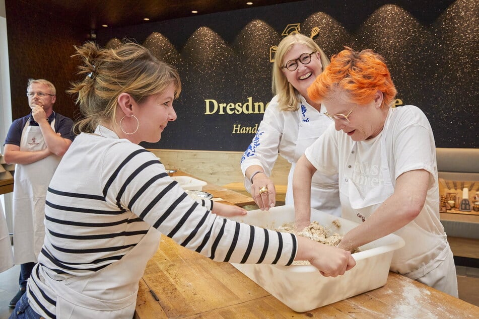 Karoline Marschallek (Stollenschutzverband, v.l.), Backhaus-Chefin Elisabeth Kreutzkamm-Aumüller und TAG24-Reporterin Katrin Koch machen sich über den Brotteig her.