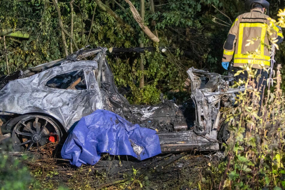 Das Wrack eines ausgebrannten Porsches landete im dicht bewachsenen Grünstreifen.