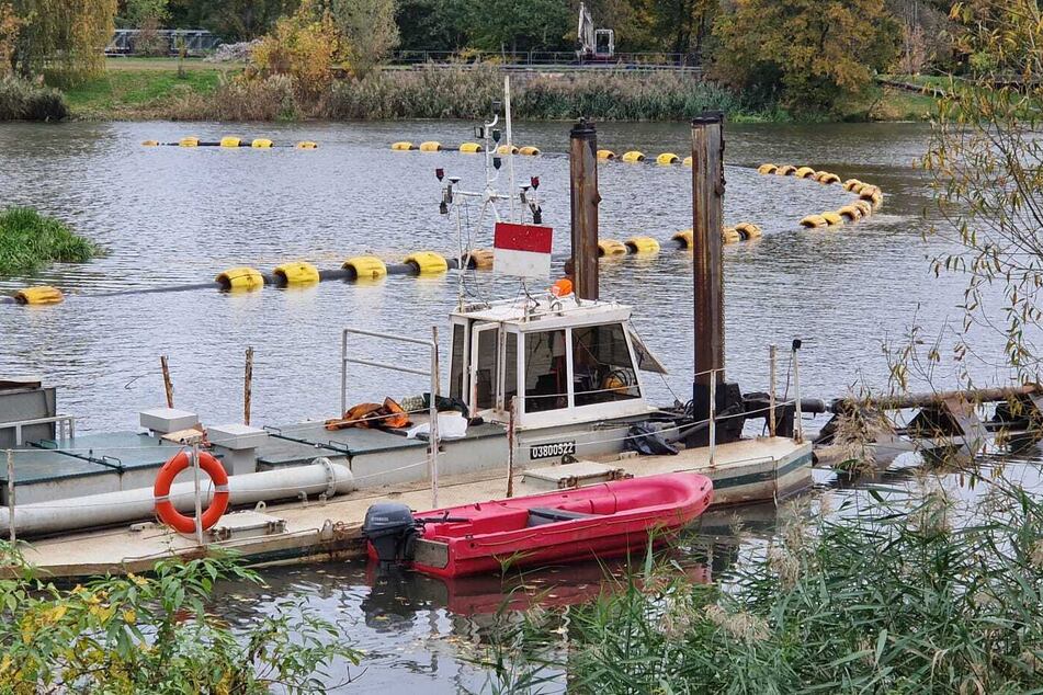 Der Saugbagger im Einsatz auf dem Elsterbecken. Die Sedimente werden über den mit gelben Schwimmkörpern gesicherten Schlauch an Land gepumpt.