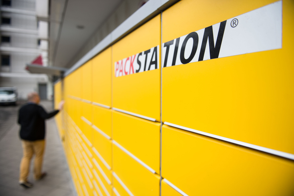 Ein Mann schließt die Paketklappe einer Packstation der Deutsche Post DHL. Wegen hoher Nachfrage will die Deutsche Post DHL ihr Netz an Packstationen stark ausbauen. (Archivbild)