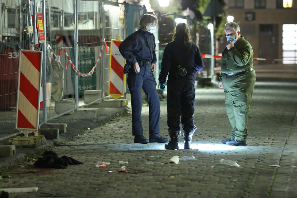 Einsatzkräfte der Polizei untersuchen Spuren am Tatort auf der Schloßstraße in Dresden.