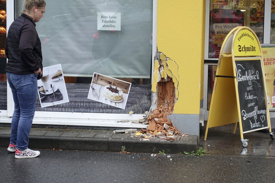 Eine Frau betrachtet den entstandenen Schaden.