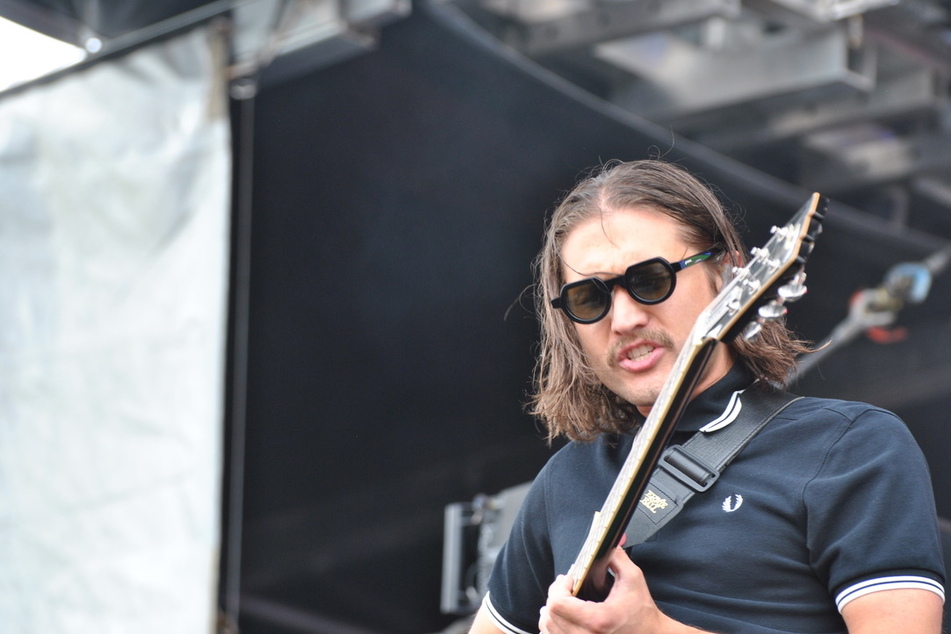 The guitarist for COIN recovered from a fall at the start of their set like a pro.