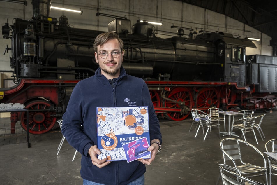 Elias Noack (23) vom Eisenbahnmuseum mit dem neuen Brettspiel "Bahnsinn!", das im August erscheinen wird.