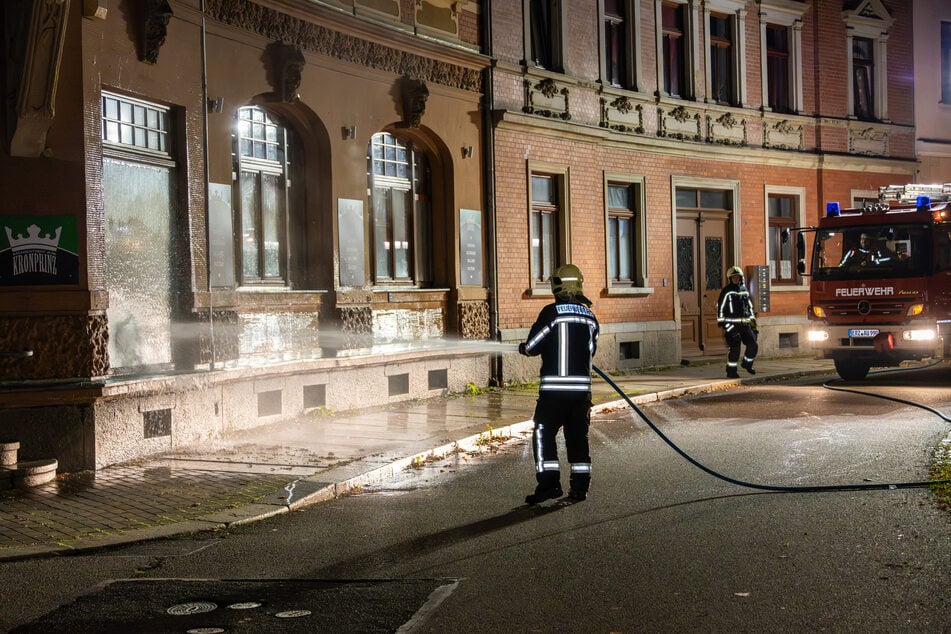 Ein Feuerwehrmann spült die übelriechende Flüssigkeit von der Wand des Parteibüros.